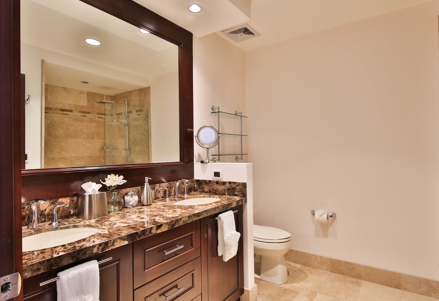 bathroom with double vanities and walk-in shower