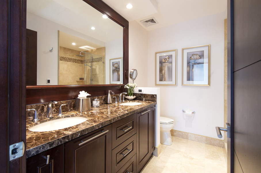 bathroom with double vanities and granite countertops