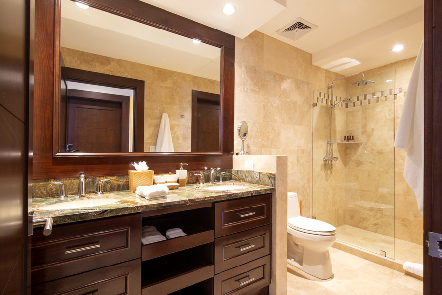 bathroom with double vanities and a walk-in shower